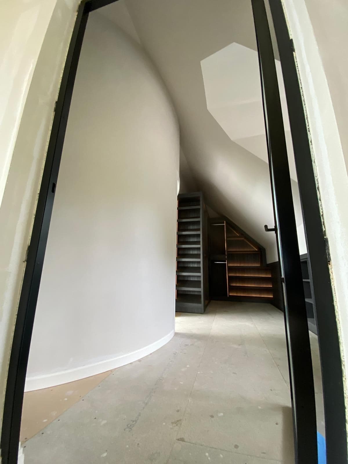 Curved wall and steel framed glazed doors leading to fitted storage
