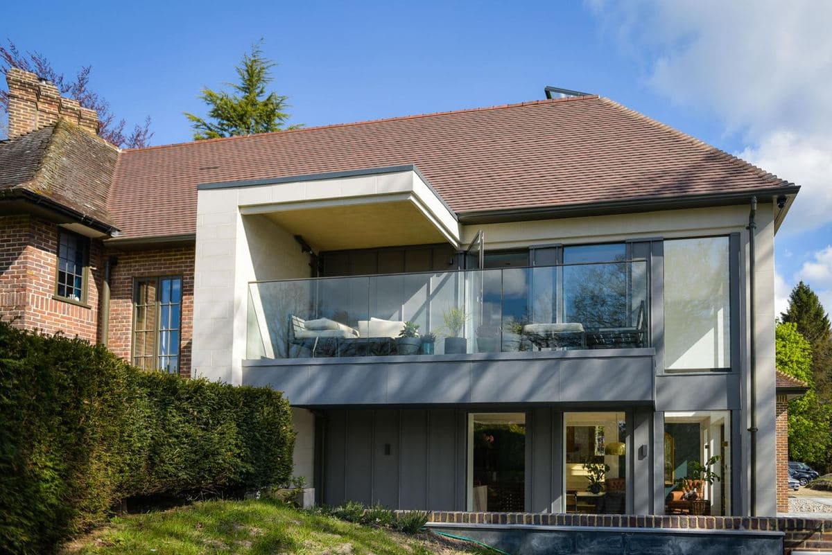 Rear of a house with a flat roof extension and glass balustrade