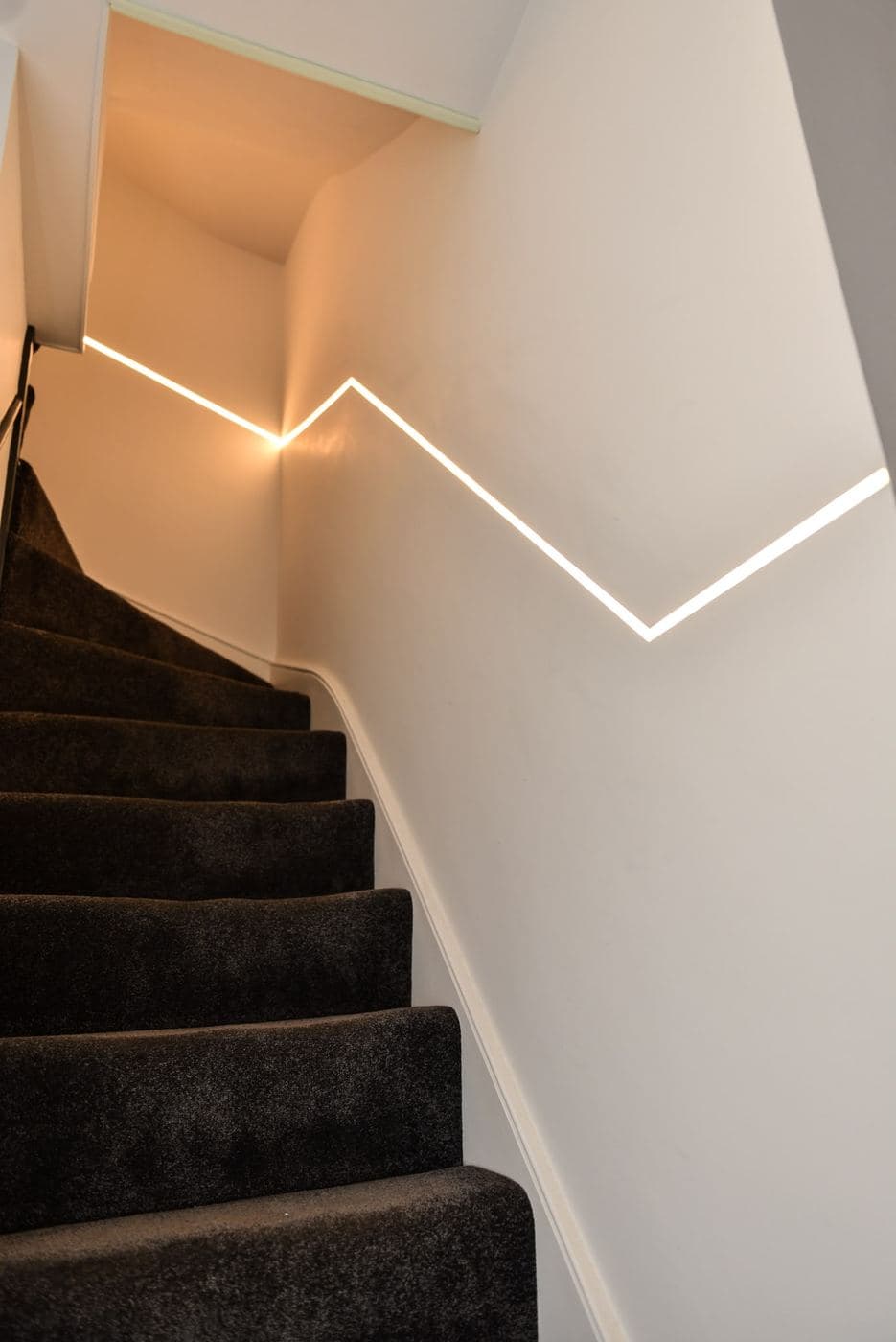 Staircase with an LED strip let into the handrail