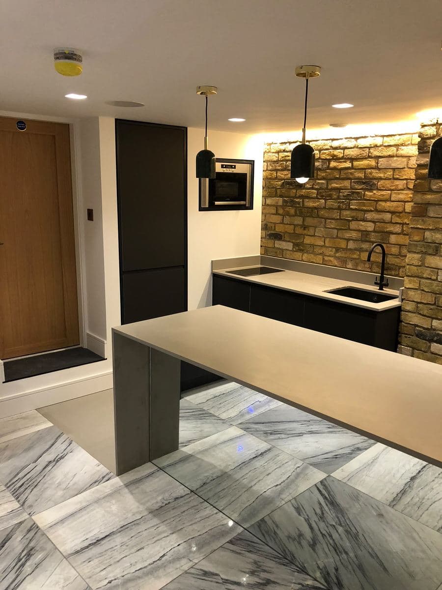 Kitchen bar seating with pendant lights over exposed brick