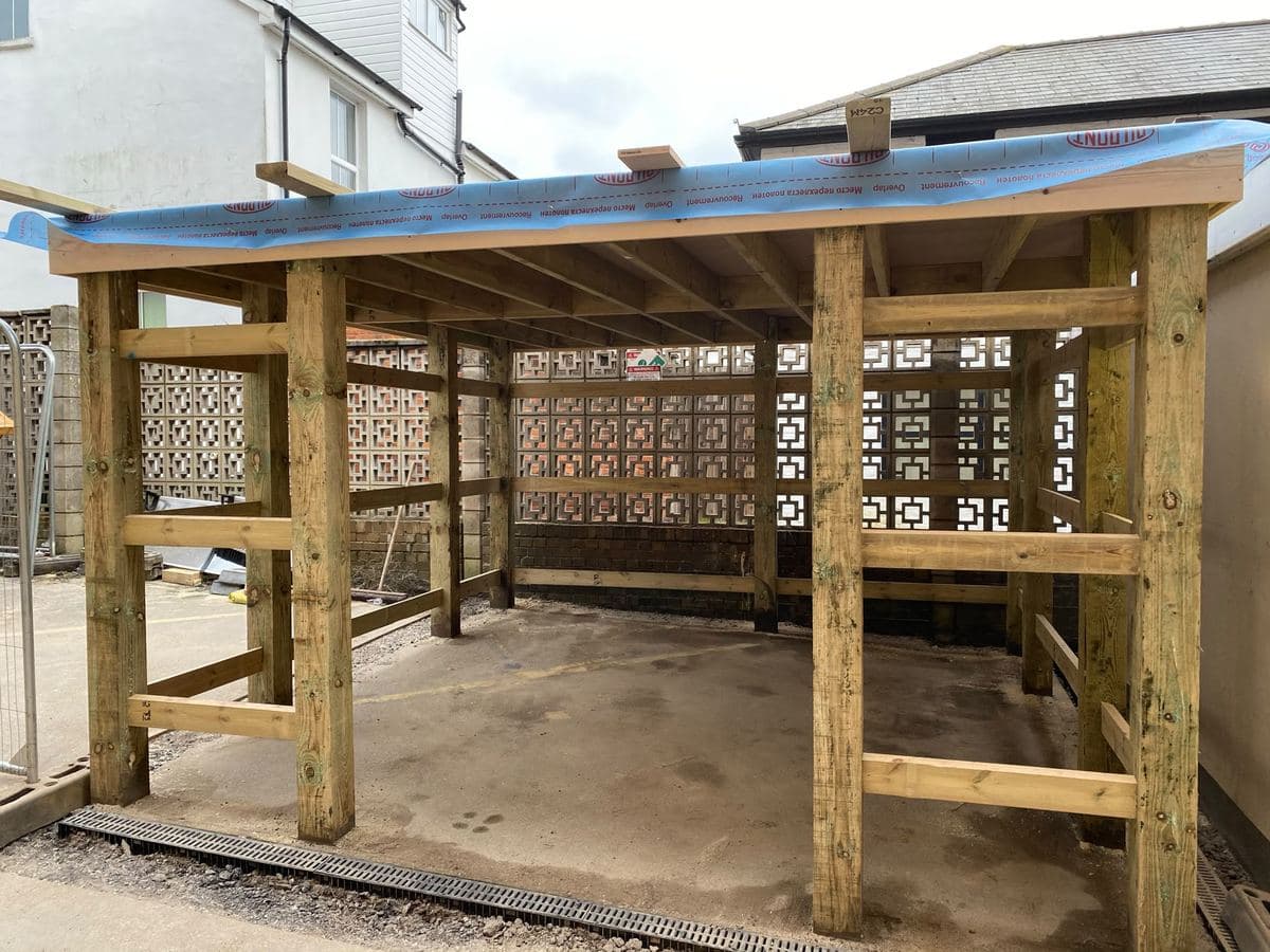 Timber pergola frame under construction over a patio