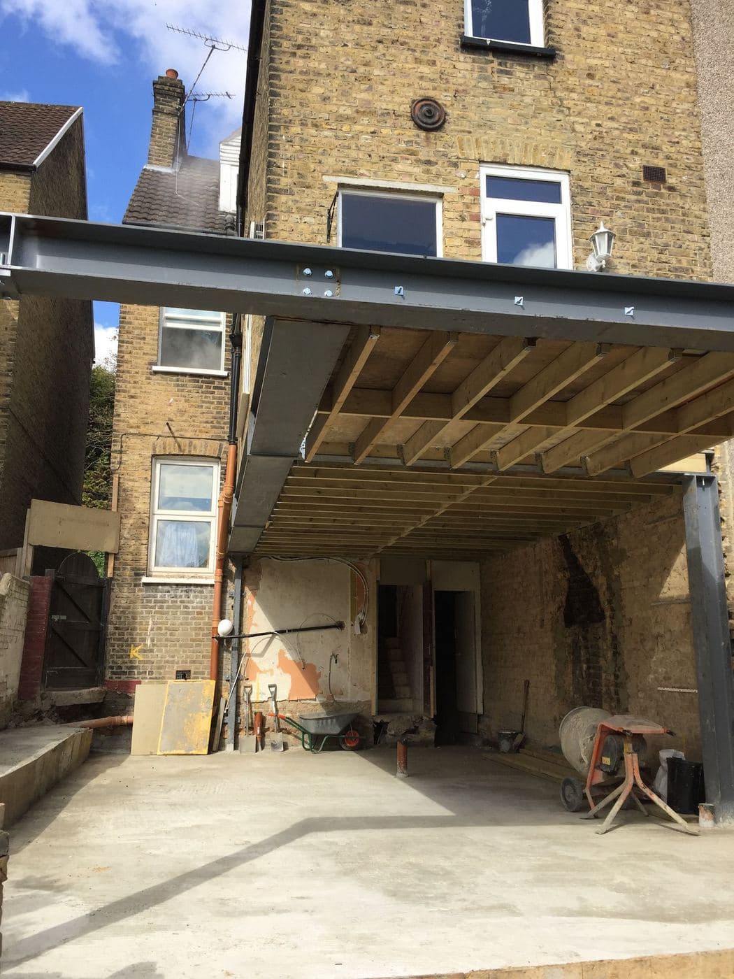 Steel beam cantilevered over a rear extension against a terrace house