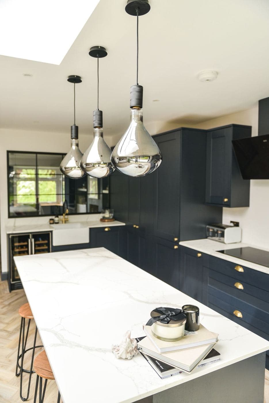 Finished kitchen island under pendant lights with a marble worktop