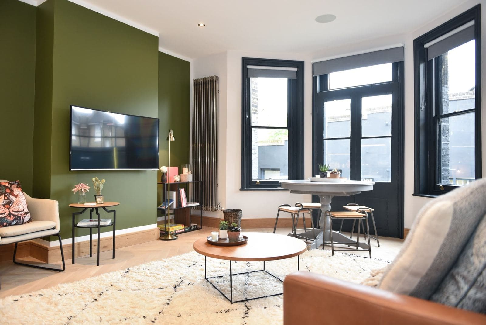 Finished living room in the short let conversion, olive green feature wall