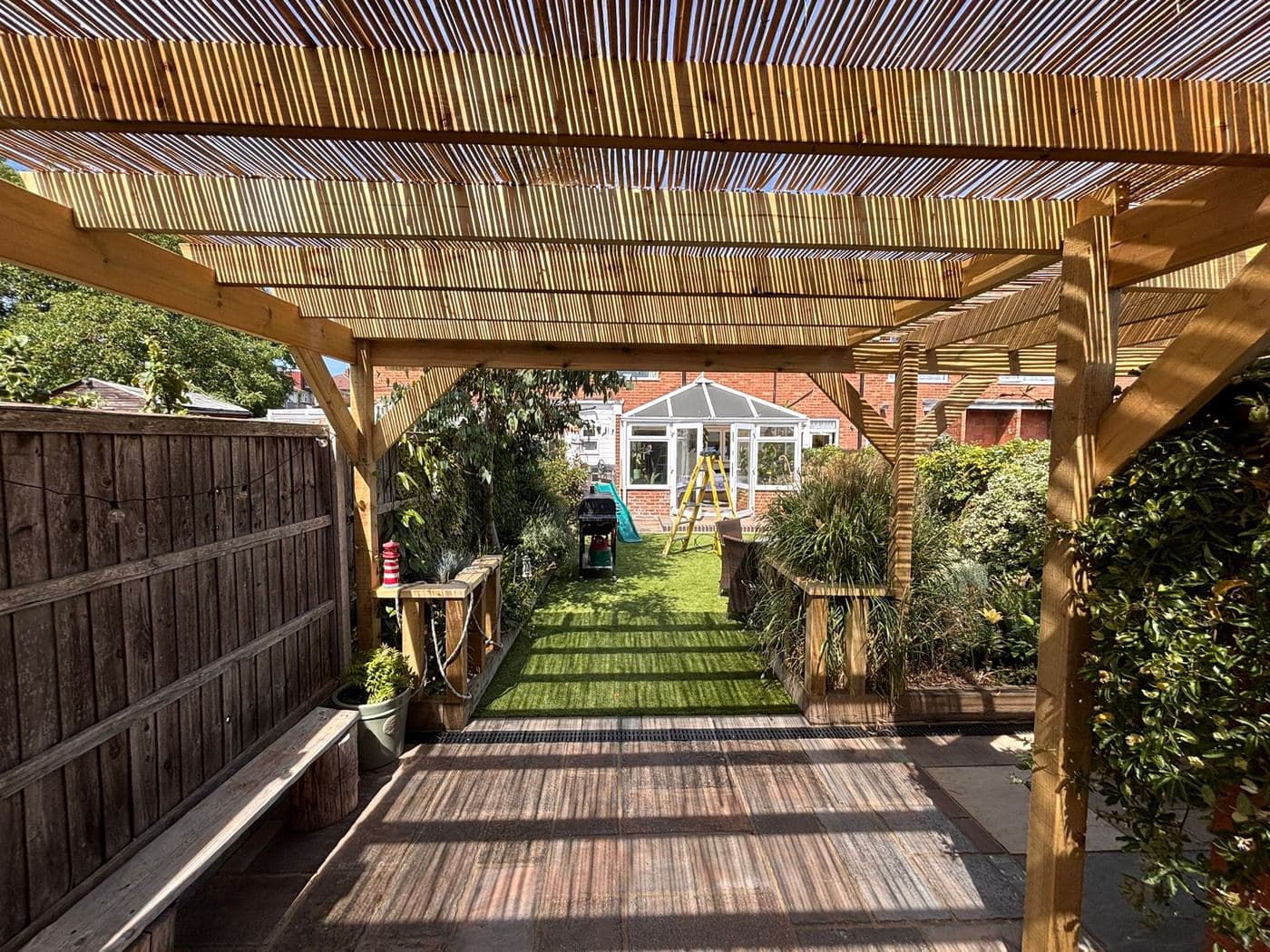 Timber pergola forming a shaded walkway through a garden