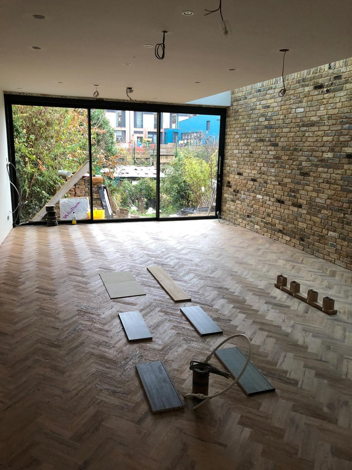 The finished extension, empty, with herringbone floor and glazed corner window