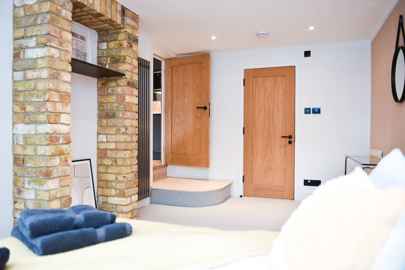 Bedroom with an exposed brick chimney breast left untouched