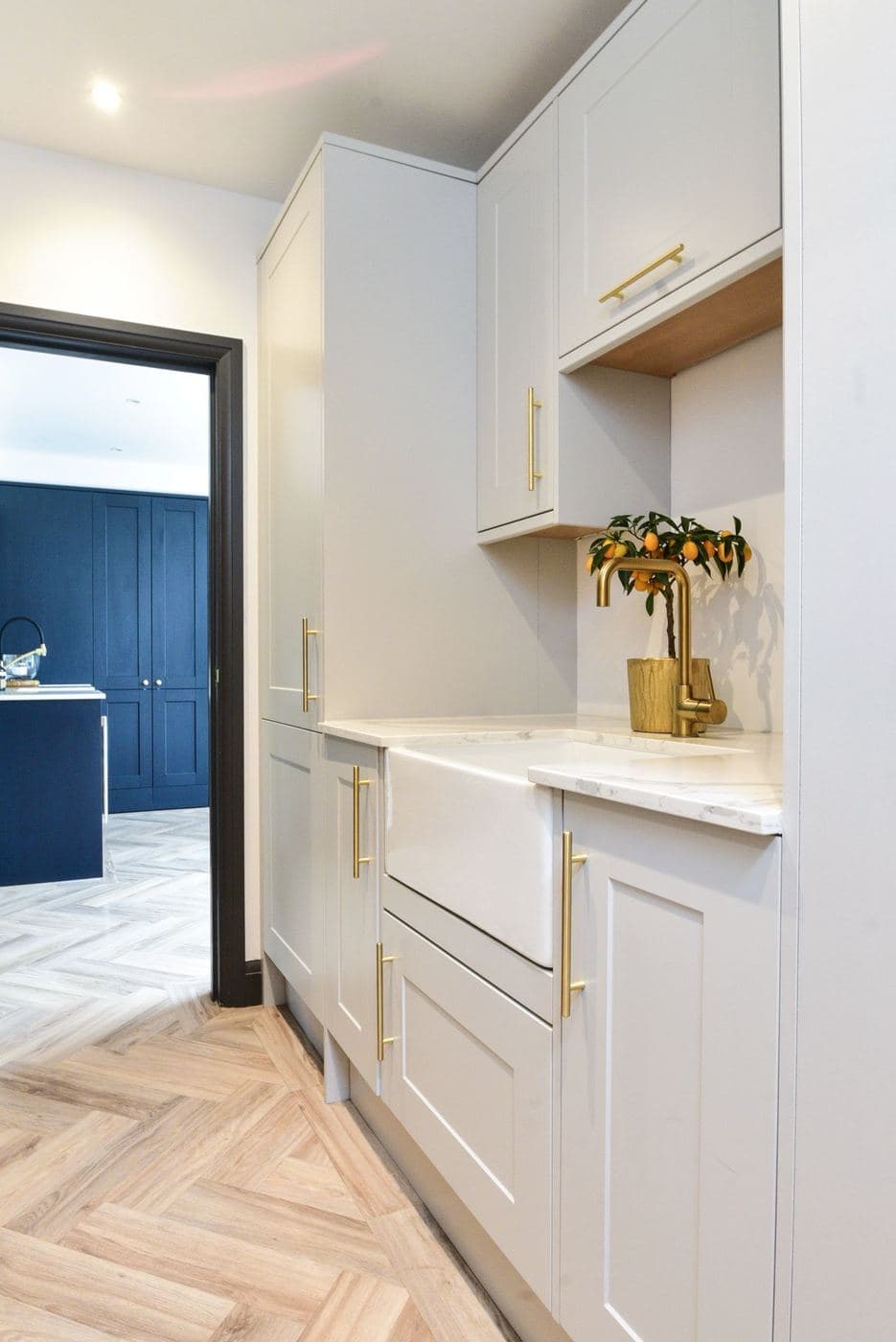 Two tone galley kitchen in navy and white with brass handles