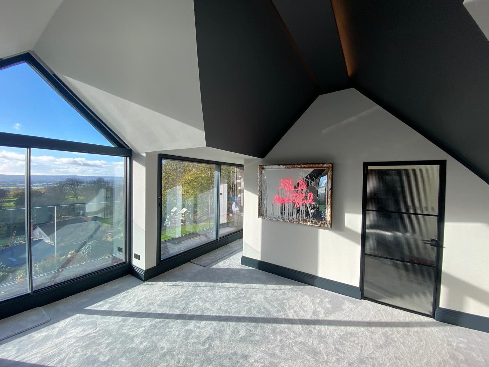 Vaulted room with full height glazing looking out over open country