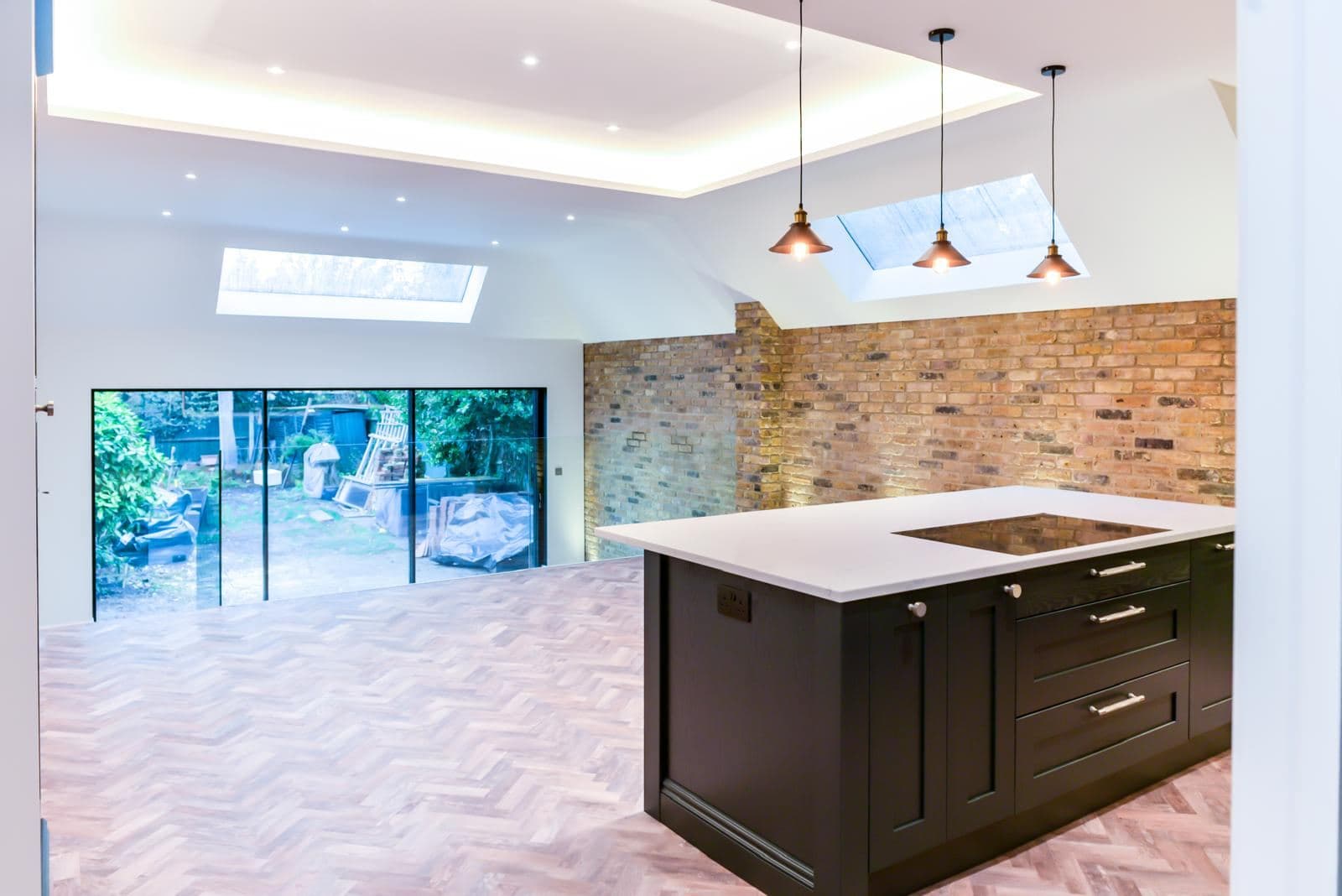 Finished open plan kitchen and living space with rooflights and sliding doors to the garden