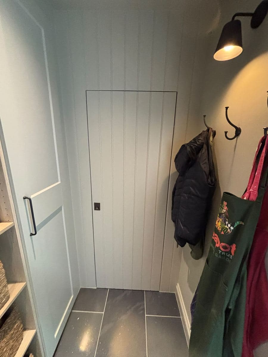 Boot room with panelled walls and coat hooks