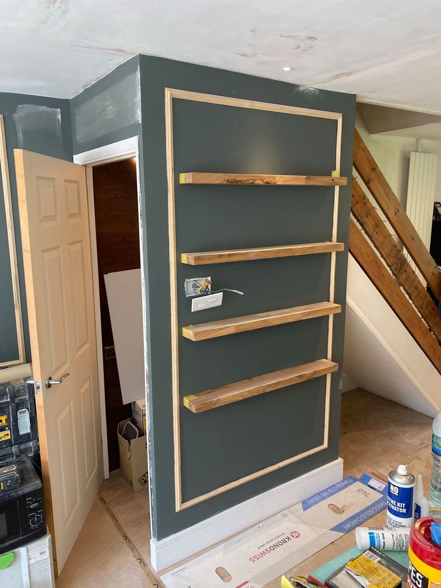 Understair shelving with brass rail, fitted into a period stairwell