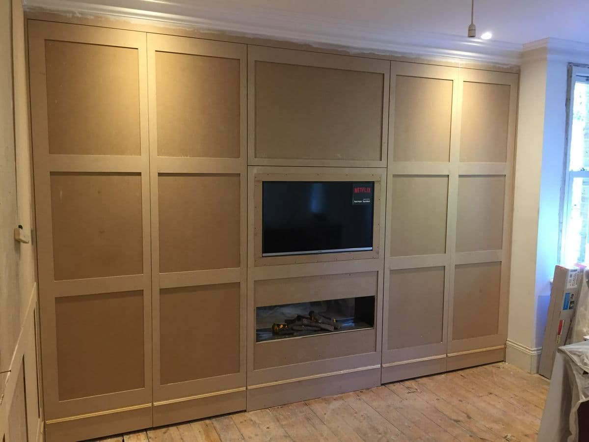 Fitted wardrobes with a recessed television and fireplace