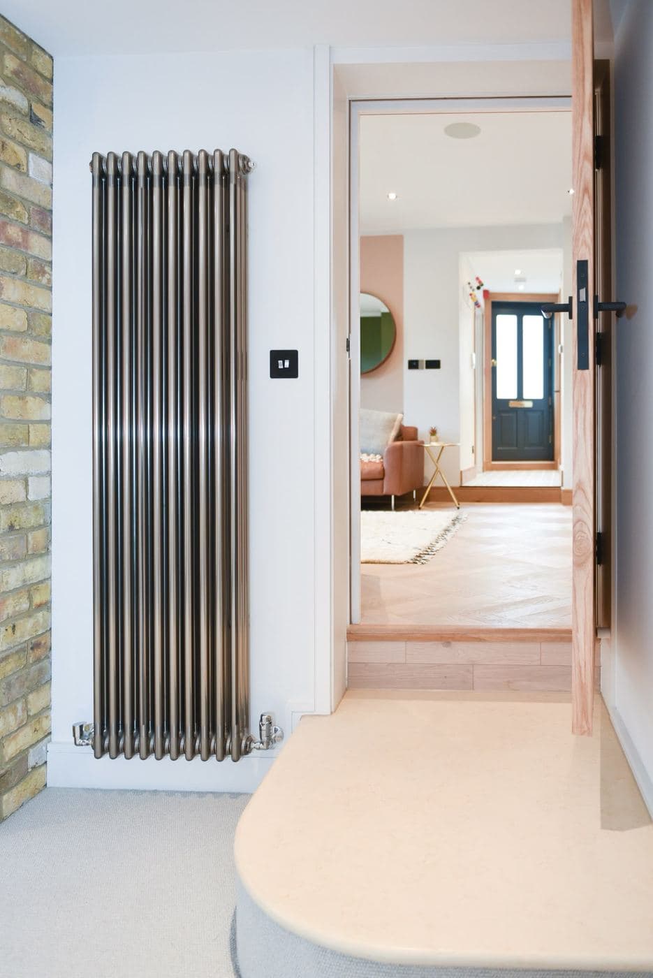 Hallway with exposed brick and a column radiator